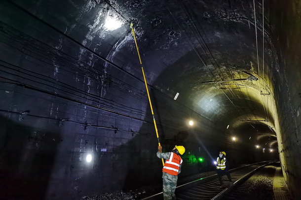 圖為兩名供電維修工相互配合隧道打冰