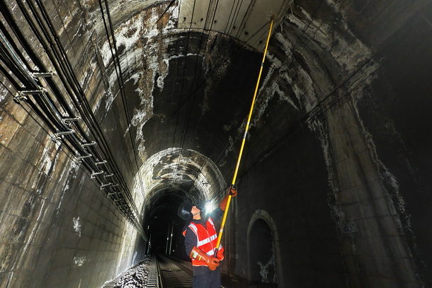 圖為供電維修工正在進行隧道打冰作業(yè)